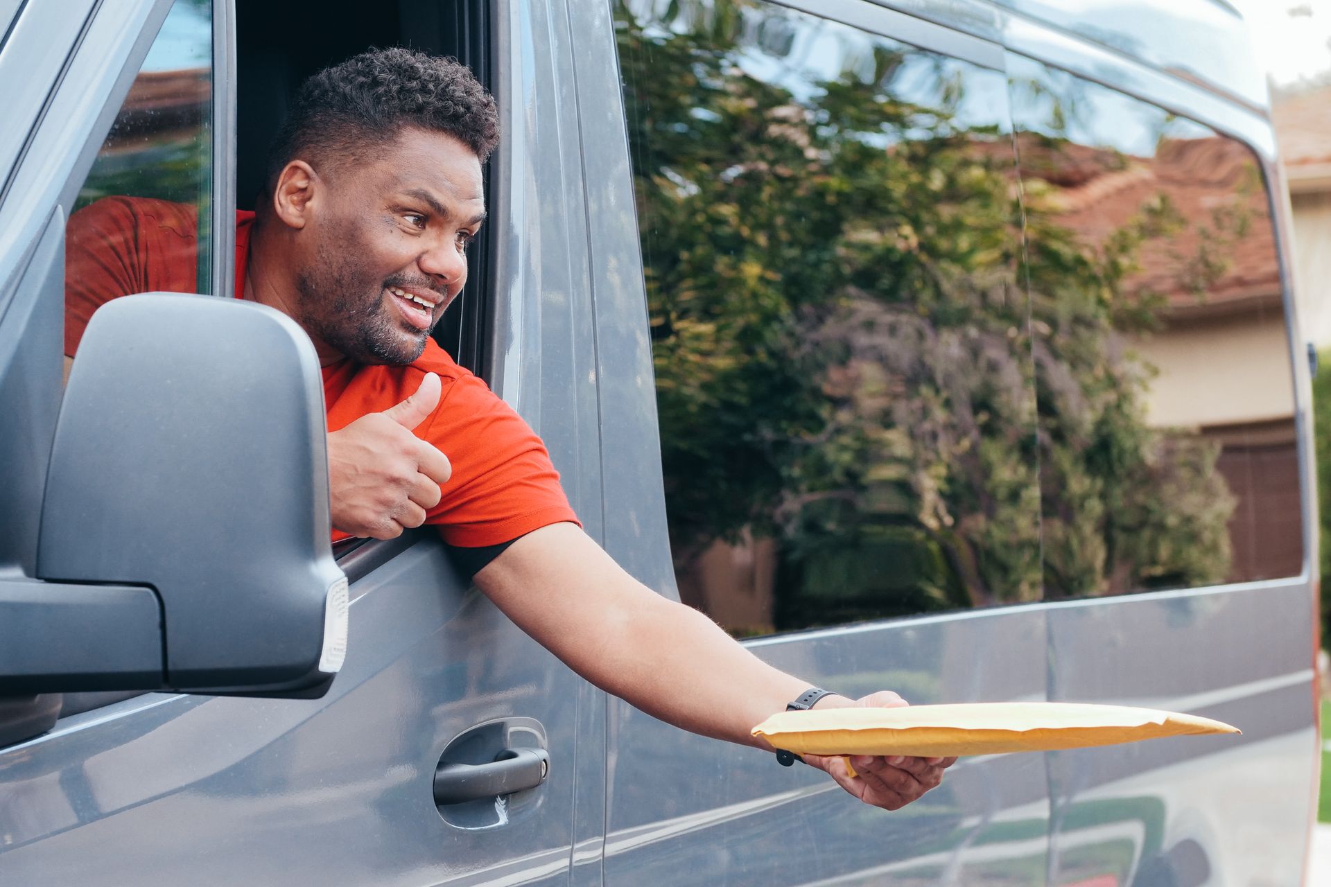 Courier delivering a parcel from a delivery van